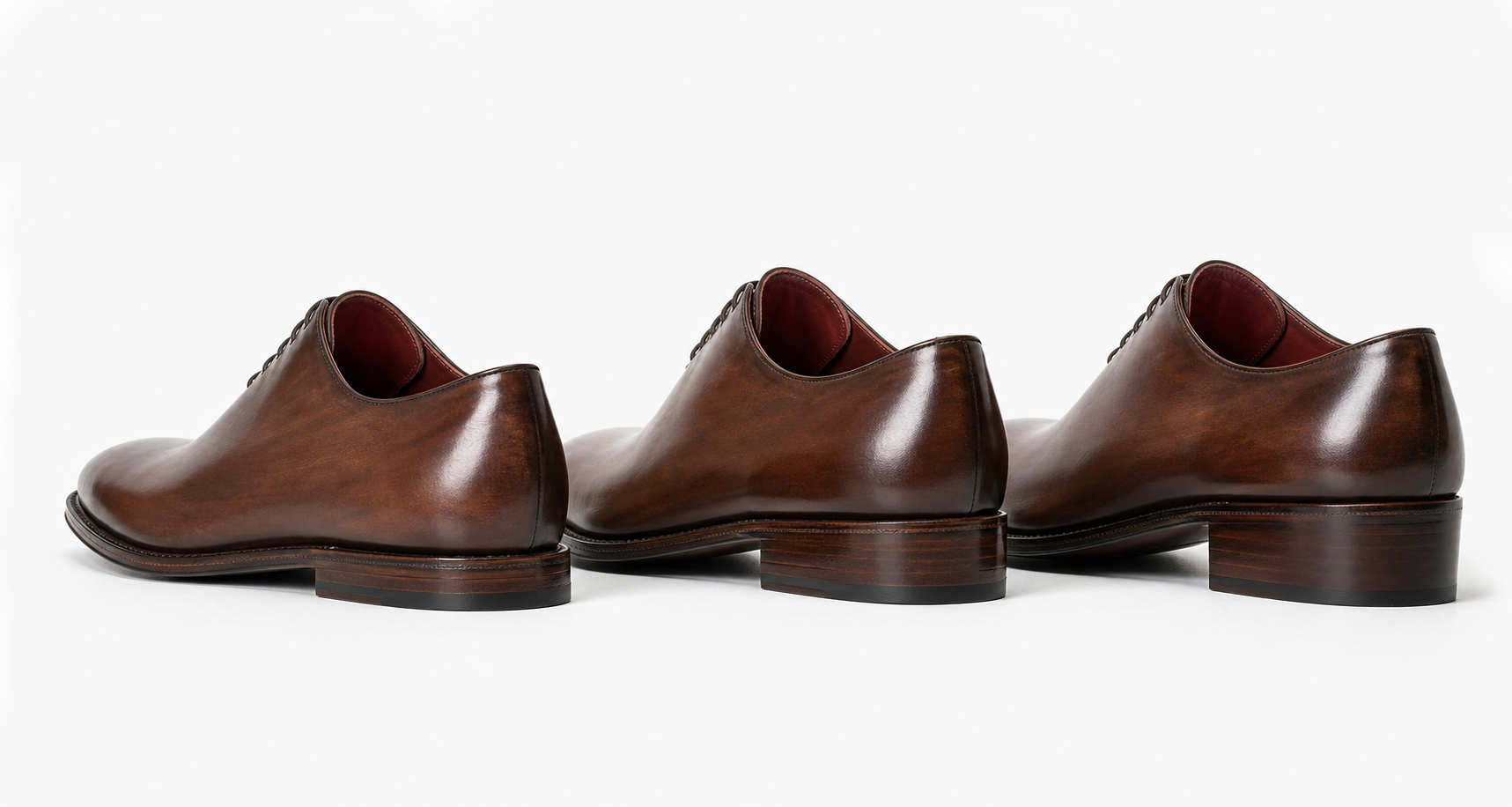 Three walnut-brown handcrafted Oxford shoes arranged by heel height