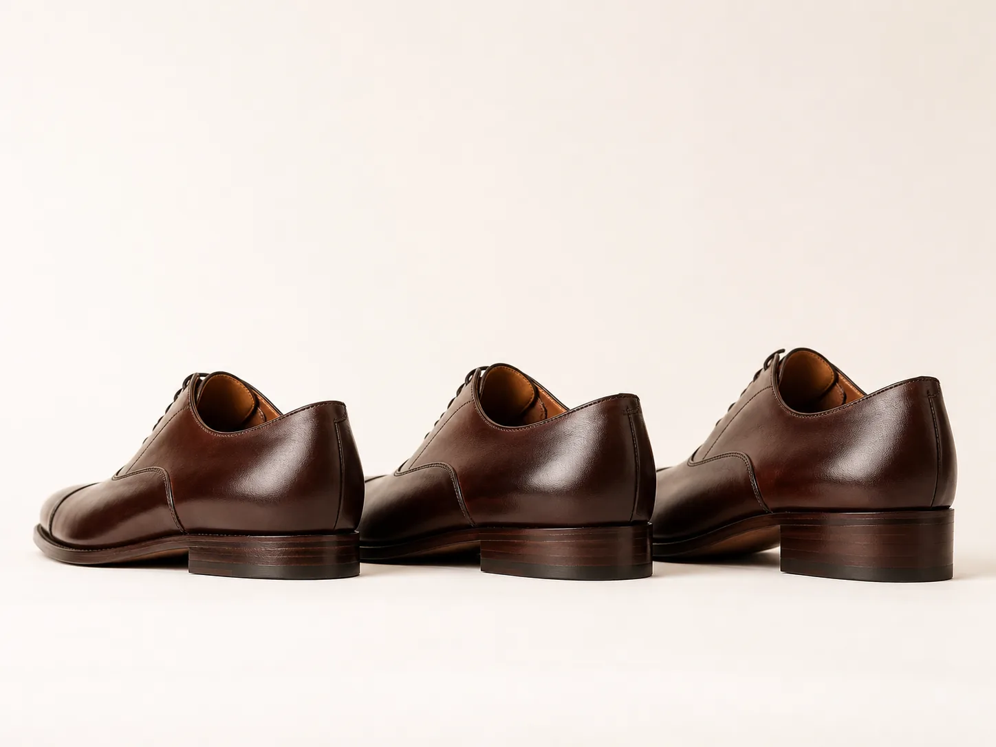 Three walnut-brown Oxford shoes with progressively higher heels